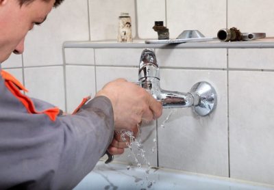 Plombier répare un robinet qui fuit