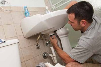 plombier répare les conduite eau du lavabo 