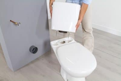 plombier assure le placement du WC